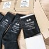 Calcetines de boda negros personalizados con fecha y nombres en caja de regalo para novio o padrino.