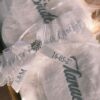 Liga de novia personalizada con encaje lazo broche joya iniciales A y M y fecha de boda.