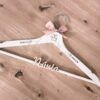 Percha de madera personalizada para novia en color blanco con nombre grabado Judit Agoney, fecha 12 de Septiembre de 2026, lazo rosa empolvado y frases en catalán Només tu i jo y Per sempre con relieve Novia, de Aura's Personality