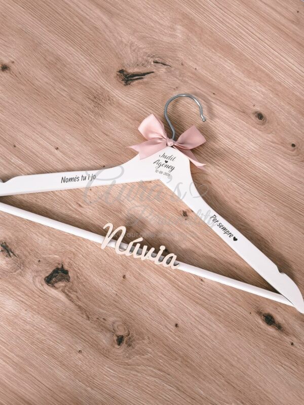 Percha de madera personalizada para novia en color blanco con nombre grabado Judit Agoney, fecha 12 de Septiembre de 2026, lazo rosa empolvado y frases en catalán Només tu i jo y Per sempre con relieve Novia, de Aura's Personality